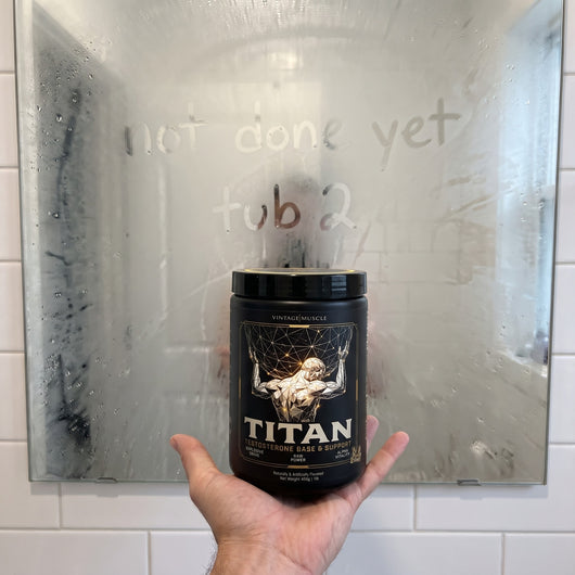 A hand holds the TITAN tub in front of a fogged bathroom mirror with not done yet and tub 2 written in the steam.